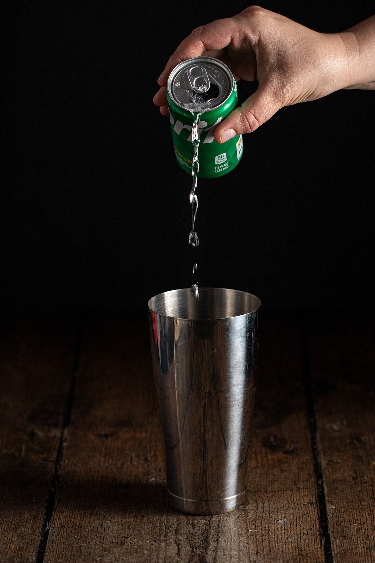 Sprite being poured into a cocktail shaker.