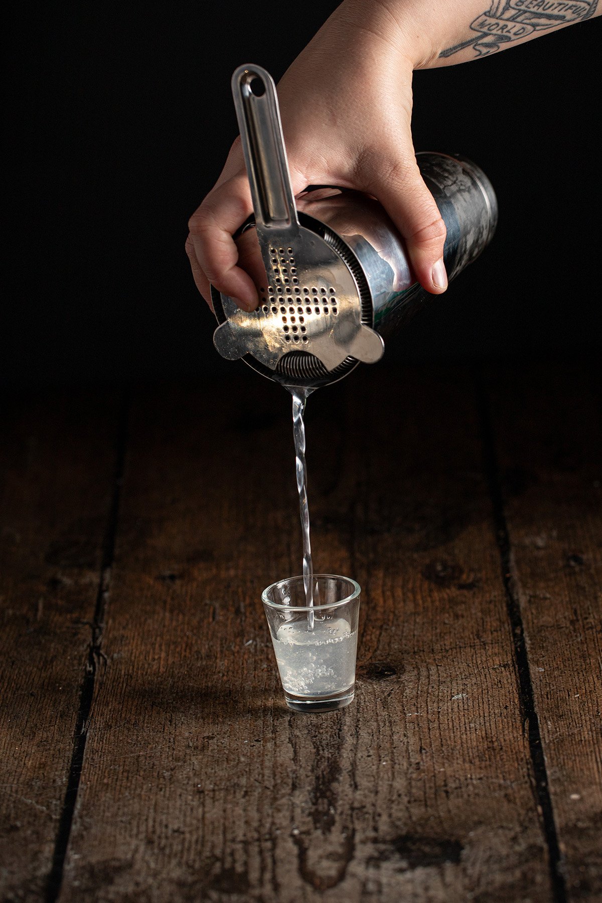 a white tea shot being poured into a shot glass.