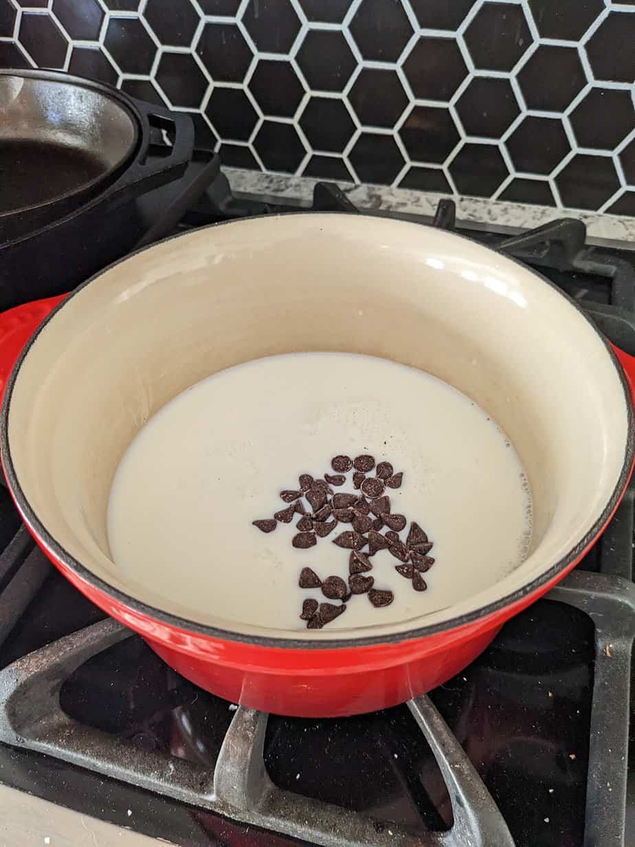 milk and chocolate chips in a saucepan on the stove