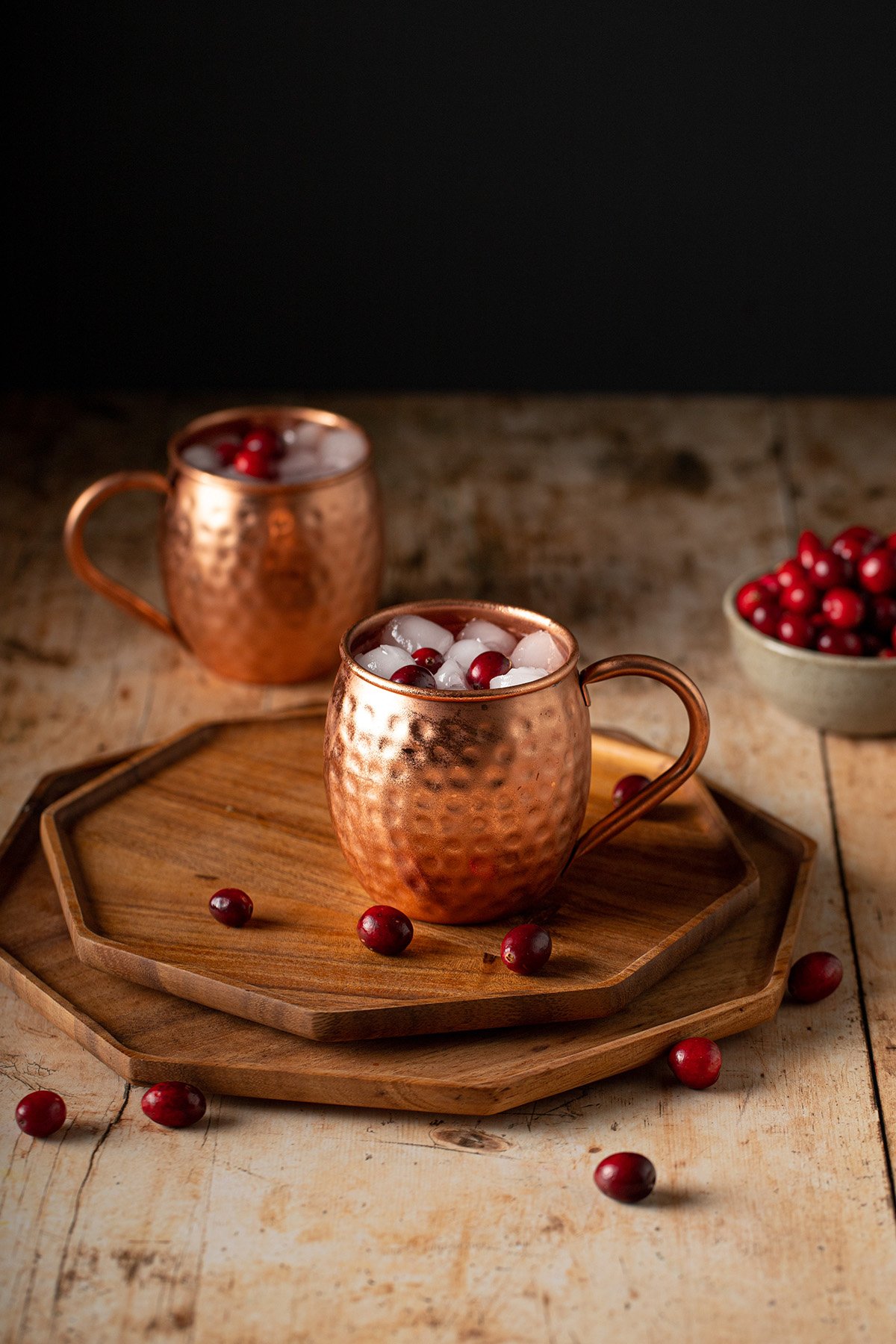 two copper mugs of cranberry moscow mules