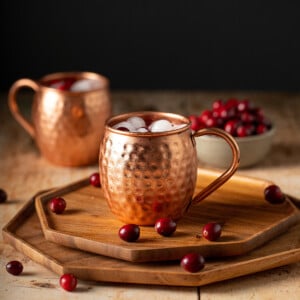 two copper mugs with cranberry moscow mules