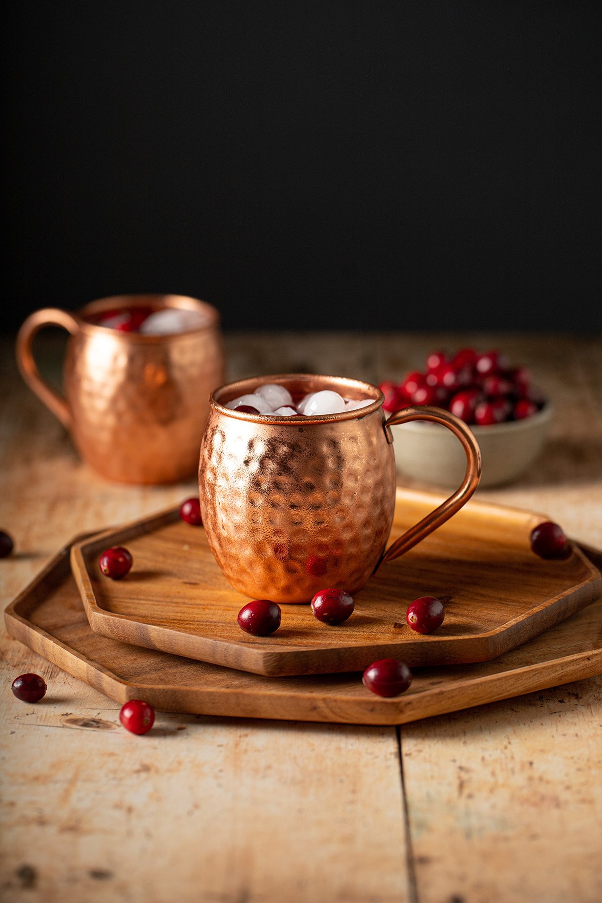 two copper mugs with cranberry moscow mules
