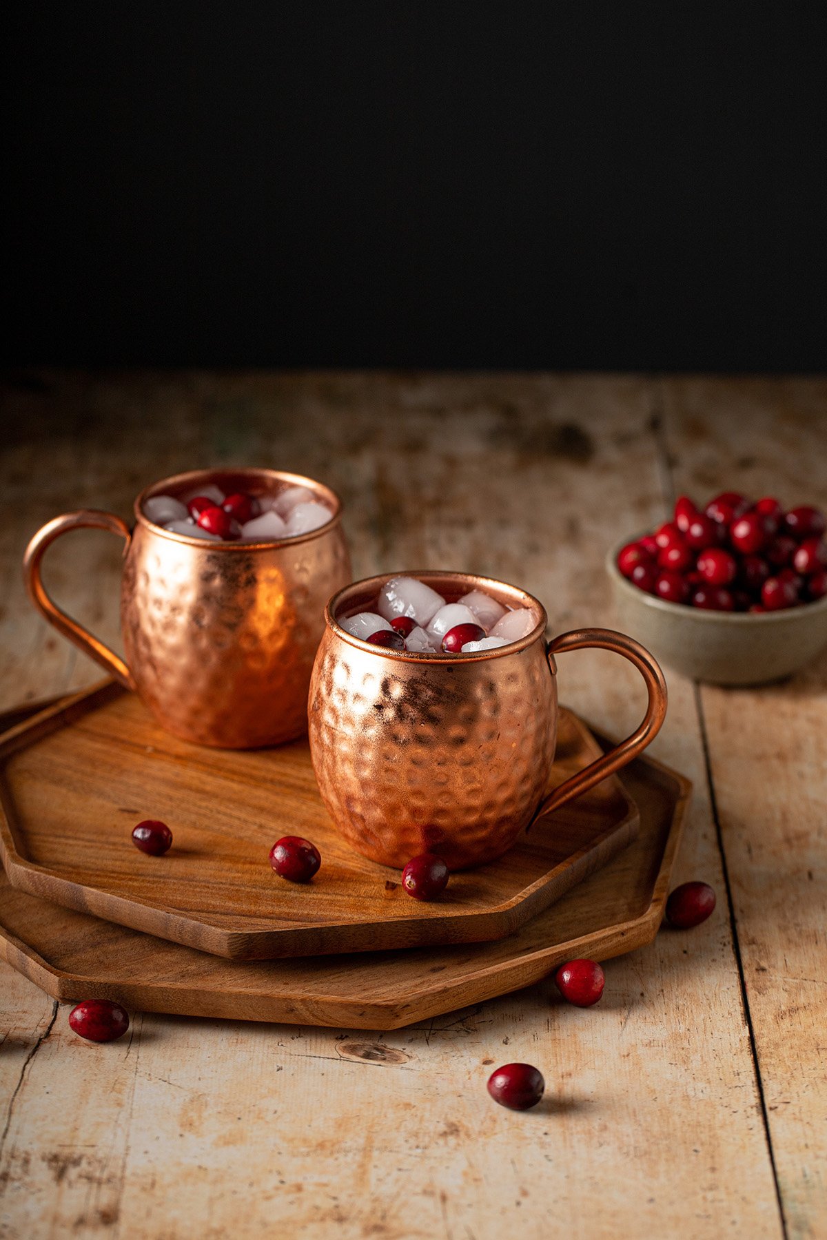 two copper mugs of cranberry moscow mules