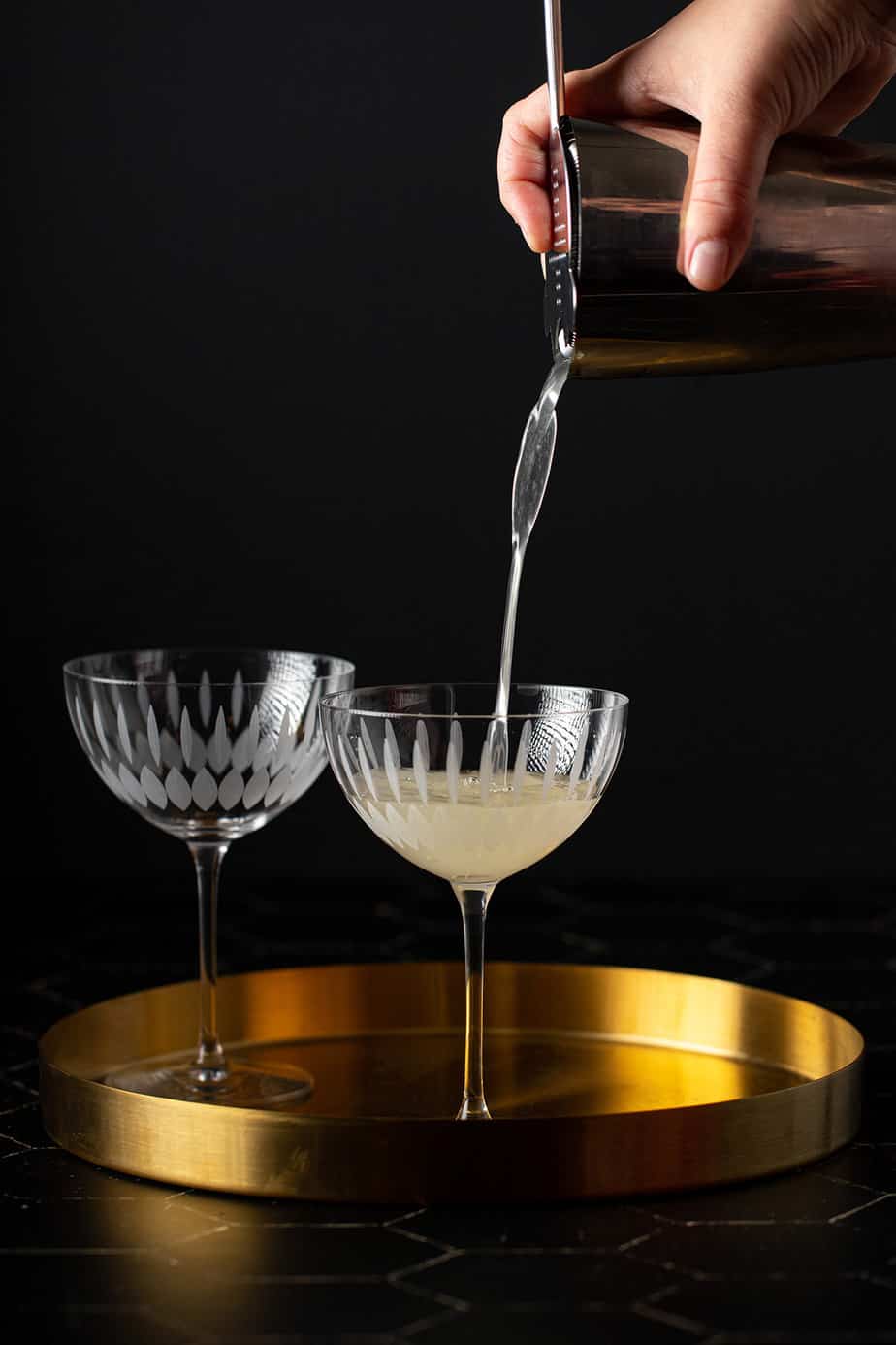 french gimlet being poured into a coupe glass