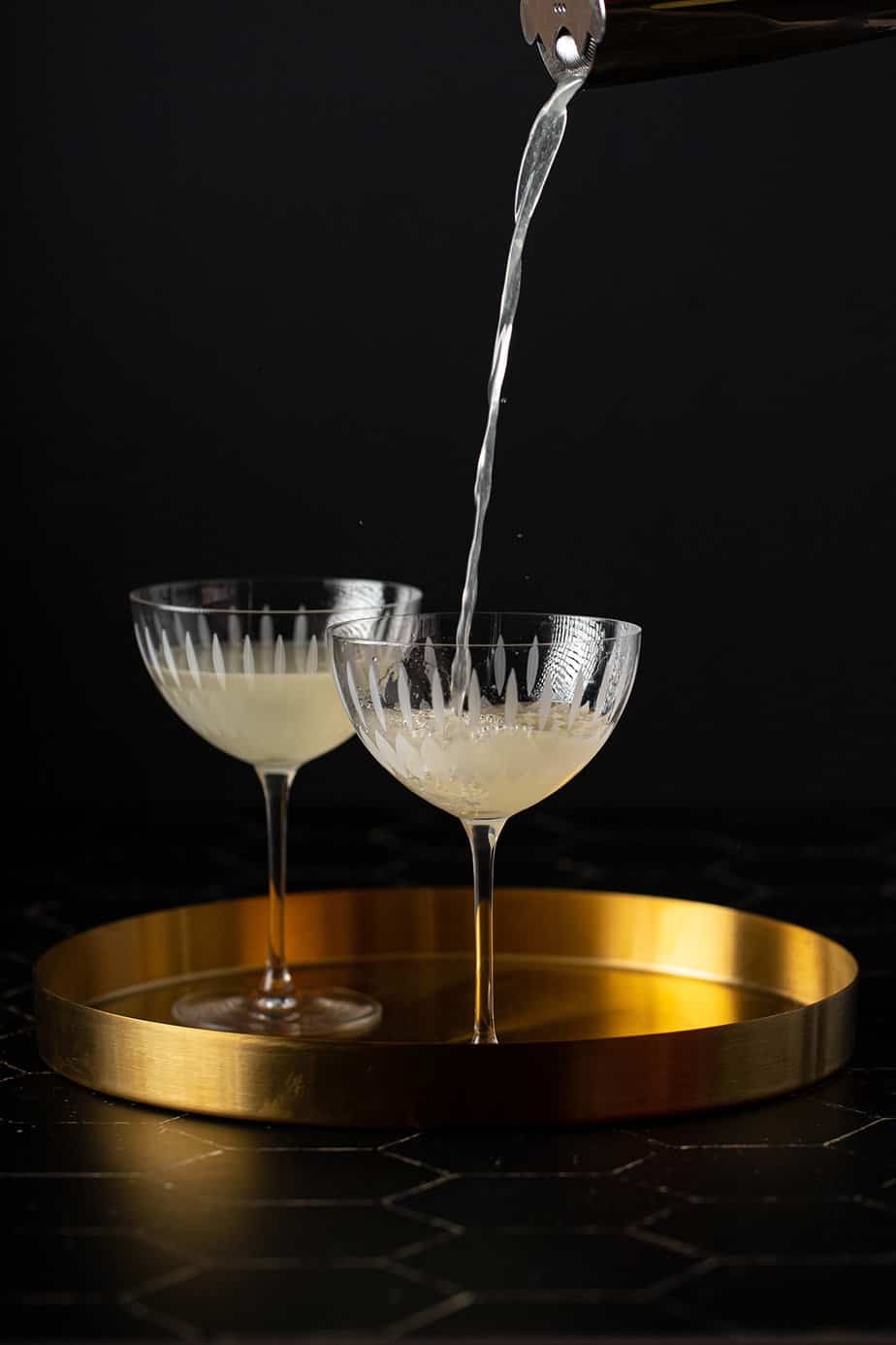 french gimlet being poured into a coupe glass