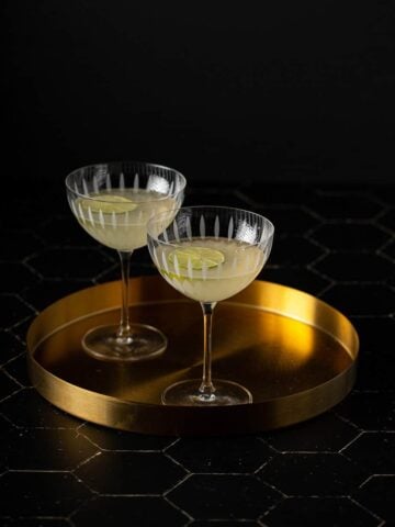 two coupe glasses with french gimlets in them