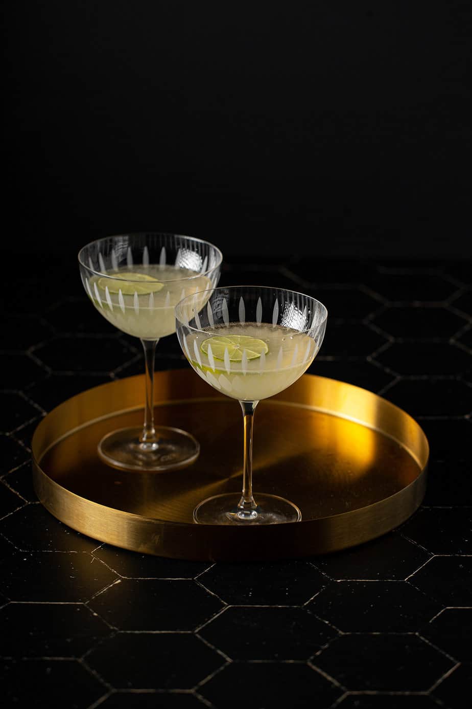 two coupe glasses with french gimlets in them