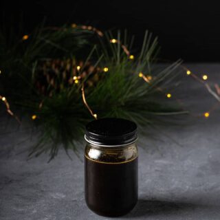 a jar of gingerbread syrup with twinkle lights behind it