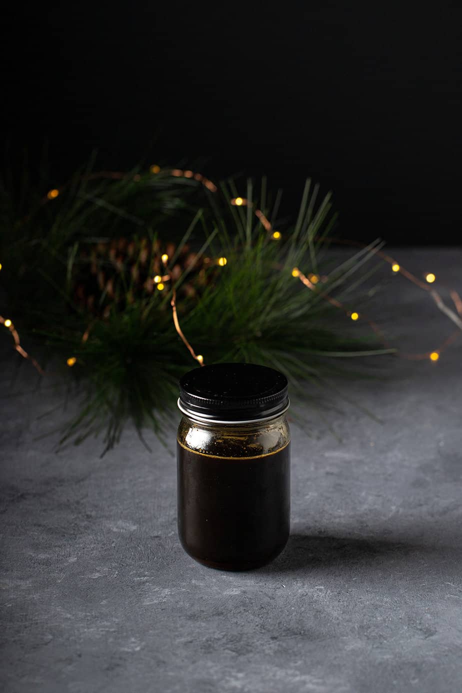 a jar of gingerbread syrup with twinkle lights behind it