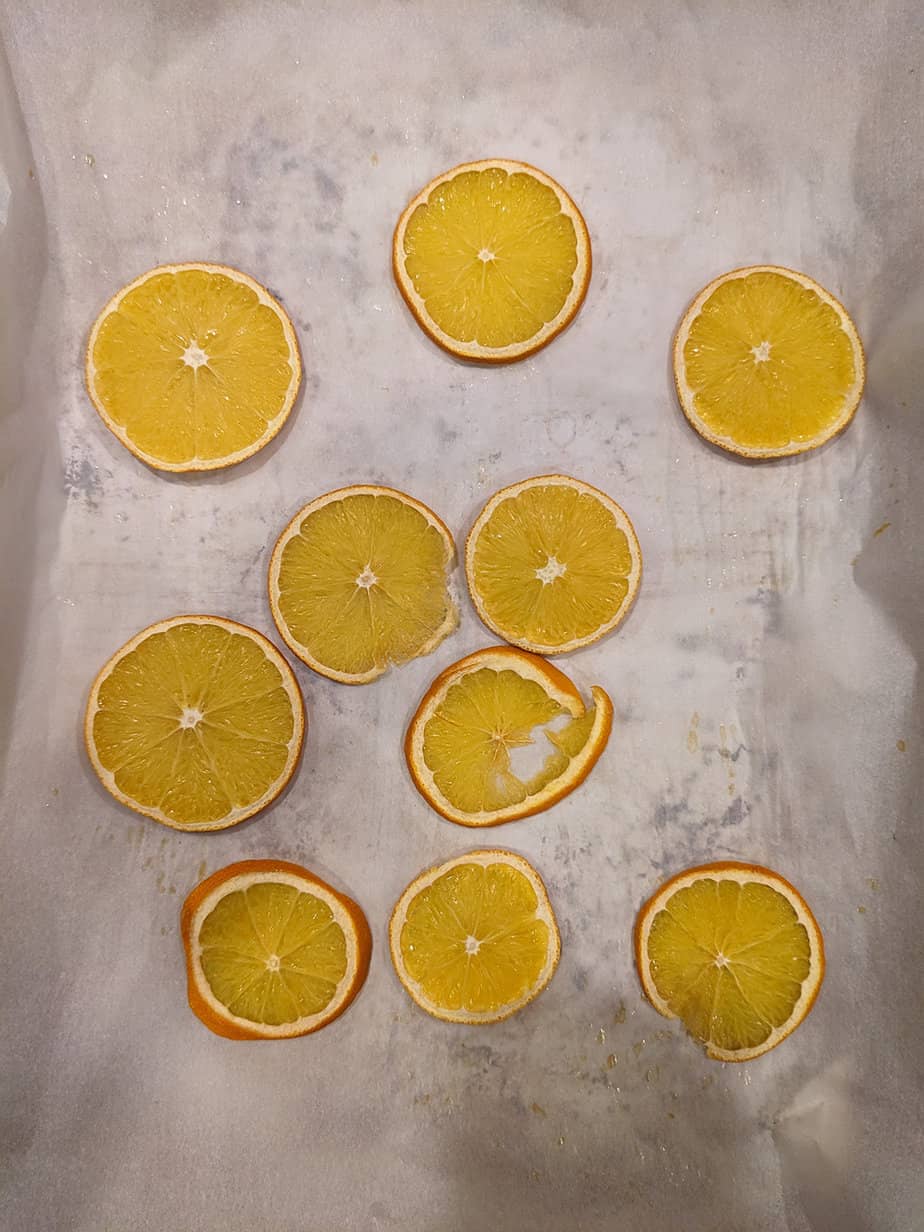 thin slices of orange on parchment paper, after being dried