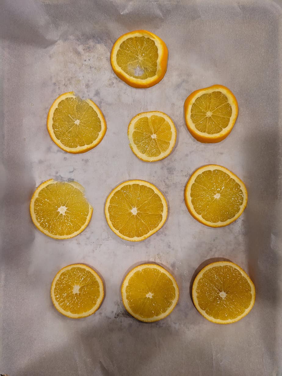 thin slices of orange on parchment paper, before being dried