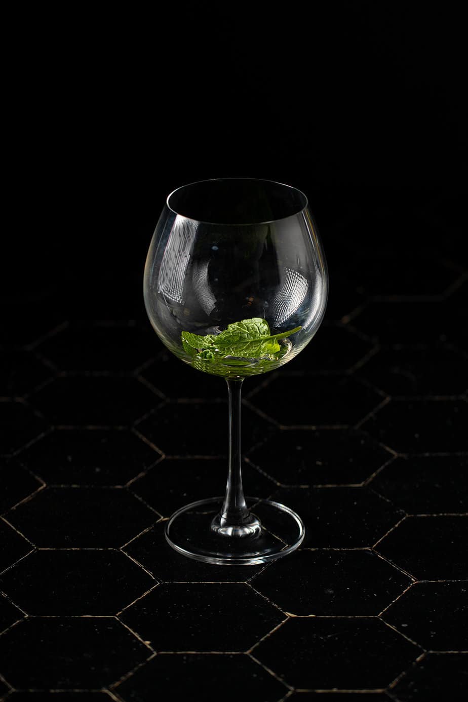 a large wine glass with elderflower liqueur and mint