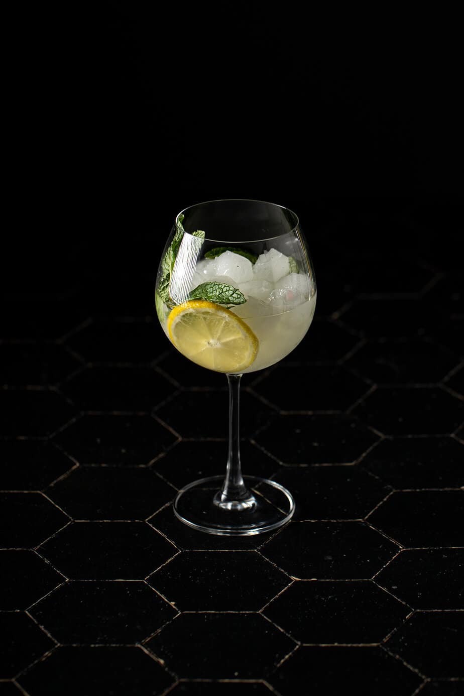 a glass with filled with a Hugo spritz cocktail