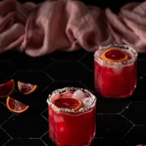 two short glasses filled with blood orange margaritas