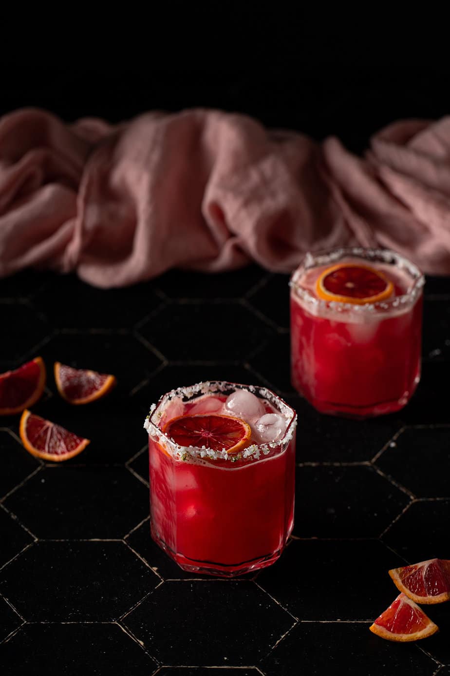 two short glasses filled with blood orange margaritas