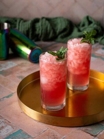 two tall glasses with crushed ice, filled with watermelon crush cocktail.