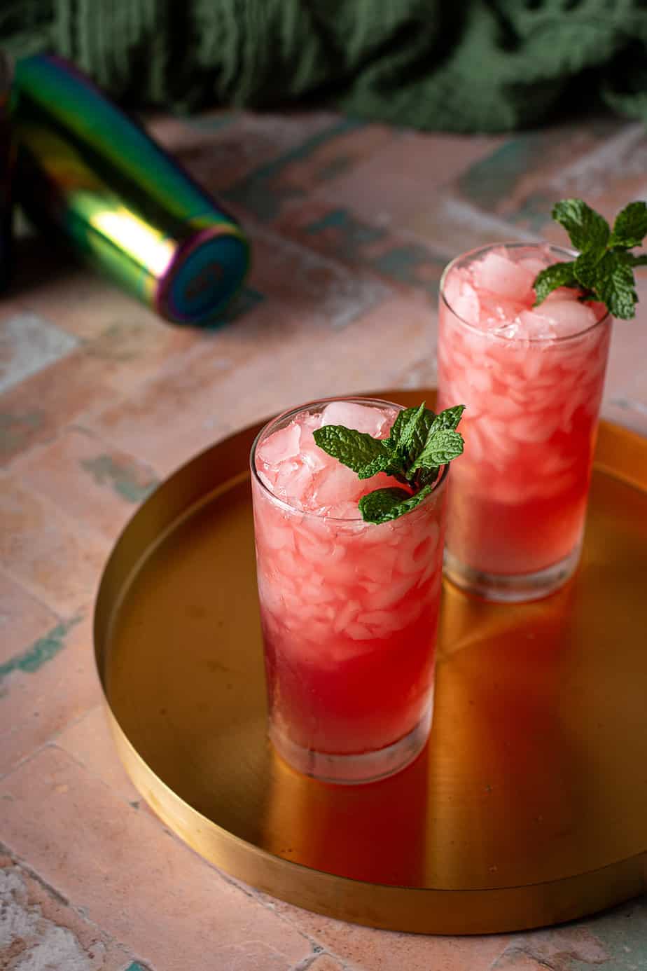 two tall glasses with crushed ice, filled with watermelon crush cocktail.