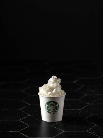 a starbucks puppuccino on a black background