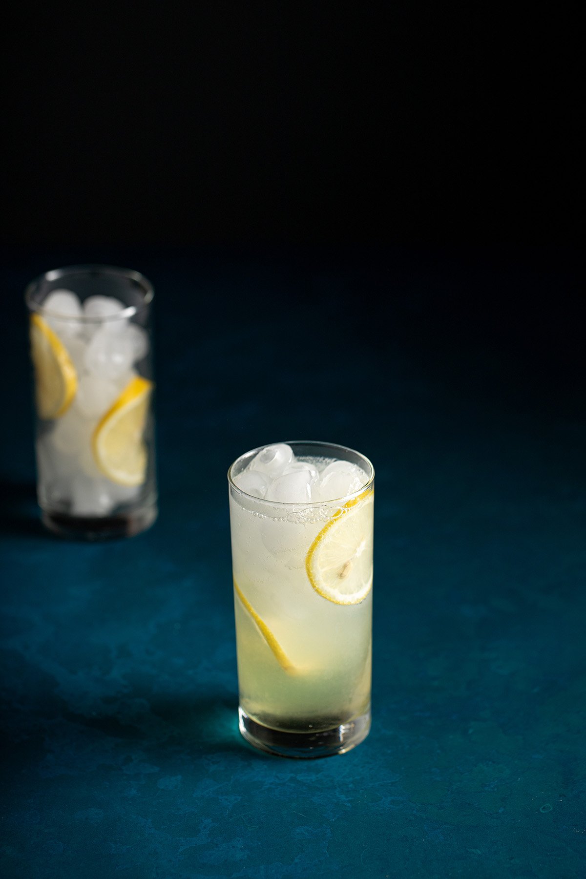 a tall glass full of ice and limoncello gin collins.