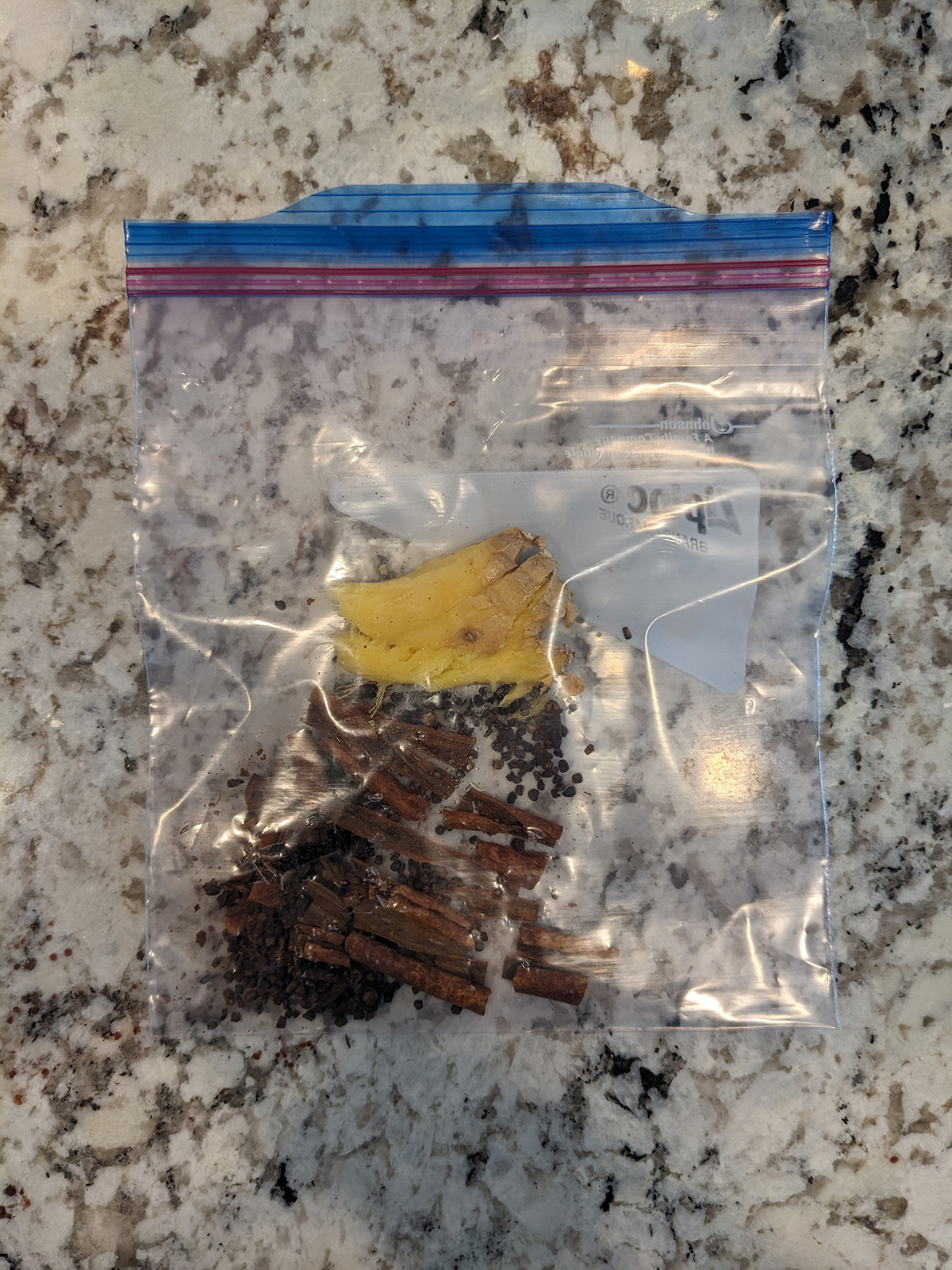 ingredients for chai concentrate in a zip top bag that have been crushed.