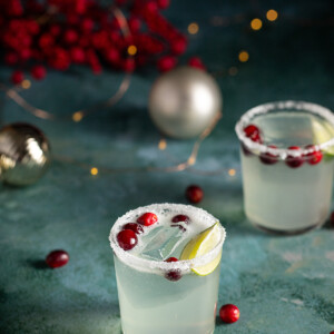 two short glasses rimmed with sugar and salt, full of white christmas margarita.