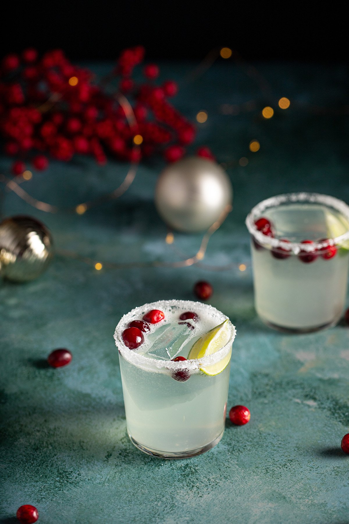 two short glasses rimmed with sugar and salt, full of white christmas margarita.