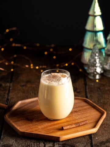 a glass of sous vide eggnog garnished with whipped cream and nutmeg.