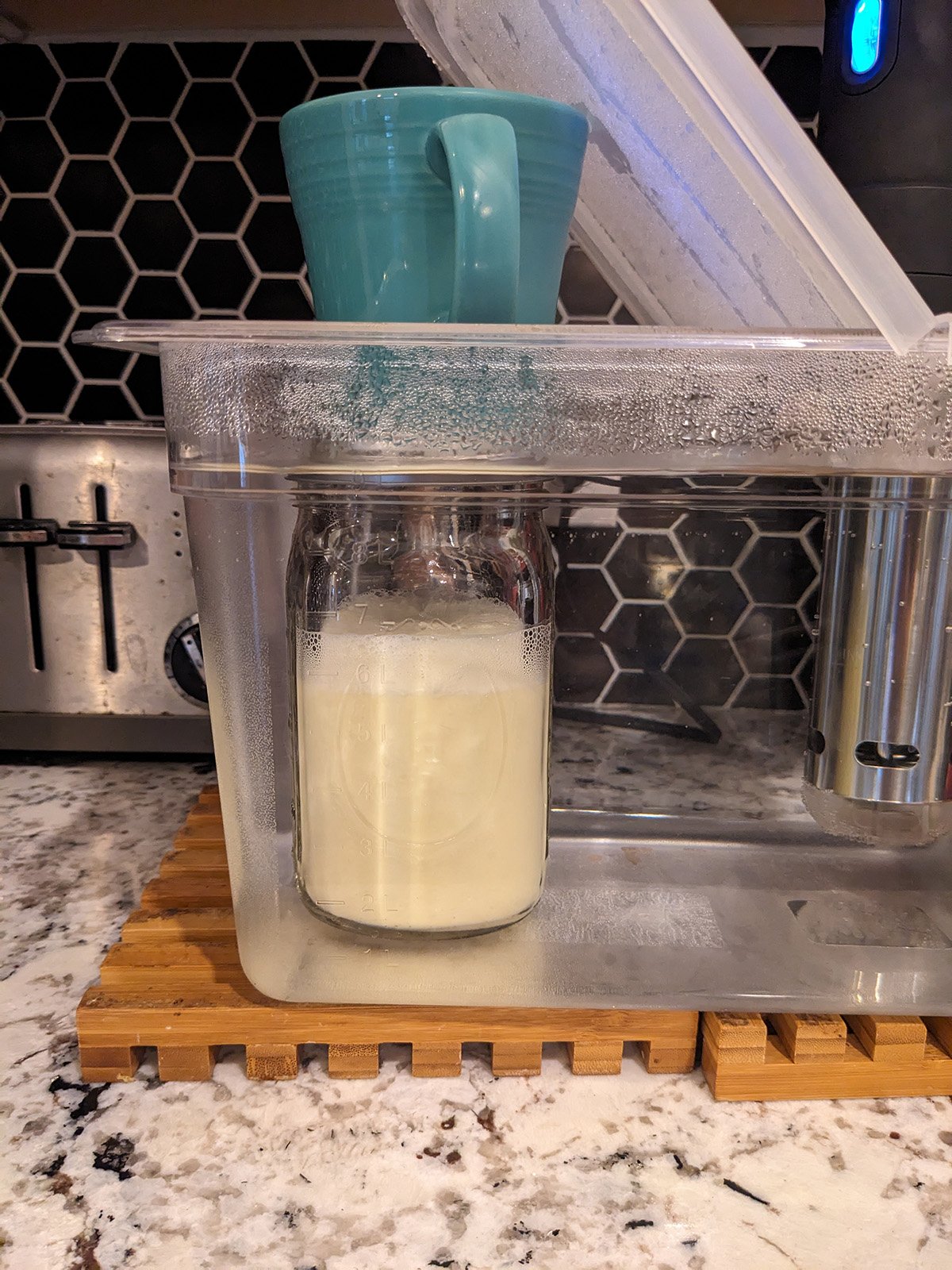 uncooked eggnog in a mason jar, submerged in water and being cooked via sous vide.