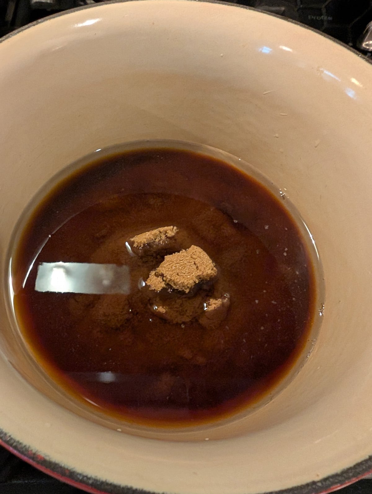 a saucepan with water and brown sugar in it.